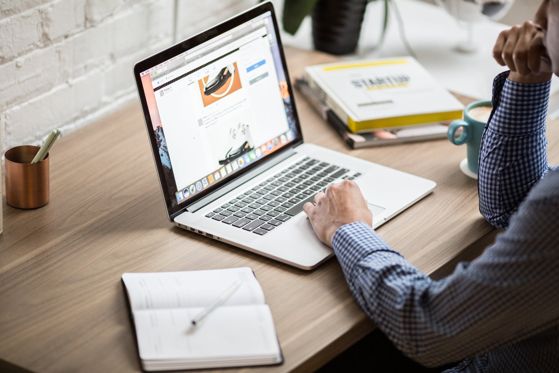 Man browsing an online shop on a laptop at a desk.